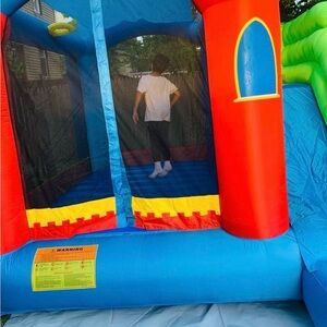 Vibrant Red, Blue, Yellow and Green Fun Bounce House. Blower included in price.